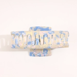 Detail of blue acetate hair claw clip showing marble texture and pearl-like glossy finish