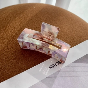 Close-up of a large square marble acetate hair claw clip with pearlescent purple finish