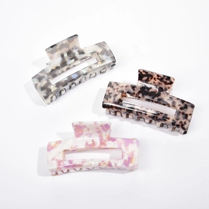 Three-piece set of large acetate hair claws in marble, tortoiseshell, and iridescent purple