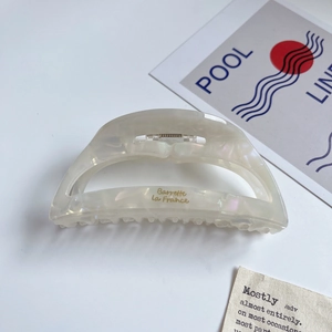 Detail of a creamy white acetate hair claw with Barrette la France golden lettering