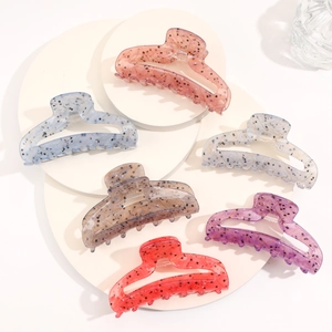 Detail showing six colors of acetate hair claws with marble texture on white display