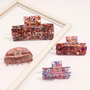 Close-up of vintage acetate hair claws in various colorful floral patterns and shapes