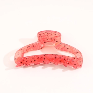 Close-up of pink acetate hair claw clip with gold and black glitter flakes detail