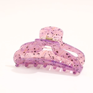 Detail of a large lilac acetate hair claw clip with stylish dark glitter flakes