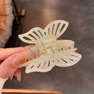 Detail of a large butterfly hair claw clip with holographic acetate finish and hollow wings