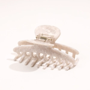Detailed view of cream acetate hair claw clip with marble texture and sturdy metal spring