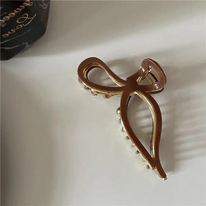 Pince à cheveux élégante en acétate caramel avec cadre doré et perles blanches