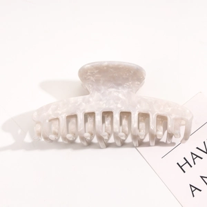 Macro detail of high-quality marbled acetate hair claw clip with polished finish