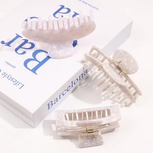 Three-piece acetic acid hair claw clip set with marble texture on decorative book