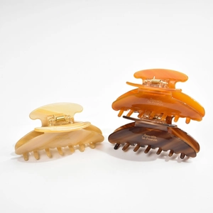 Detailed view of large acetate claw clips in amber tones with Barrette La France text