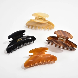 Set of four large acetate shark hair claws in black, tortoiseshell, amber, and beige colors