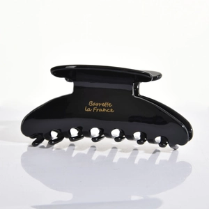 Detail view of high-gloss black claw clip featuring golden Barrette la France script lettering