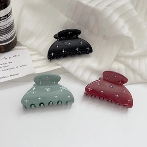 Three acetate hair claws in black, sage green and burgundy with star rhinestone pattern