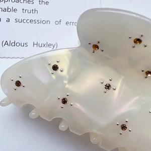 Elegant ivory pearl hair claw clip featuring amber rhinestone accents for women