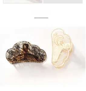 Detailed view of medium-sized cloud-shaped hair claws with lace inlay and gold stars