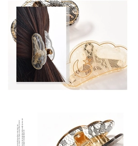 Detail showing elegant lace cloud hair claw with golden moon and star patterns