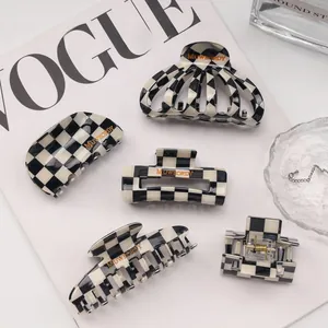 Detailed set of five black and white checkered hair claws in various geometric shapes
