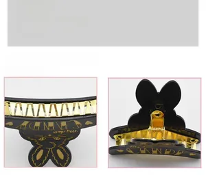 Detail of cute black rabbit hair claw clip with gold accents and internal metal teeth