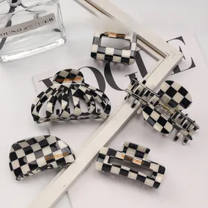 Detailed set of five black and white checkered acetate hair claws in various elegant shapes