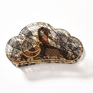 Detailed view of cloud-shaped acrylic hair claw with lace patterns and gold moon stars