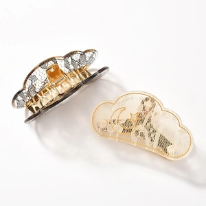 Detailed close-up of acrylic lace hair claw clips with black patterns and gold stars