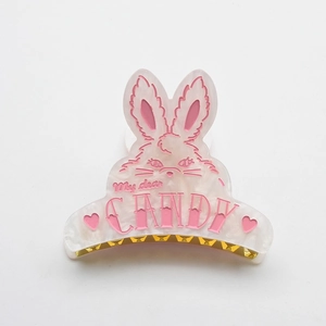 Detail of a rabbit-shaped acetate hair claw clip with My dear CANDY text and gold teeth