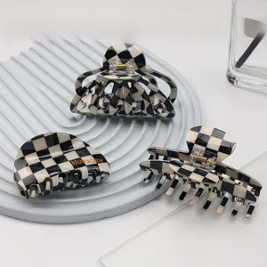 Close-up of three checkered hair clips on a tray, showing durable springs and resin finish