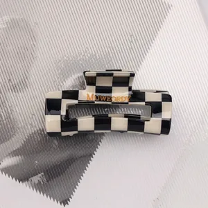 Close-up of a rectangular black and white checkerboard hair claw clip made of acetate