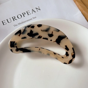 Detail shot of the tortoise shell acetate hair claw with Creation France gold lettering