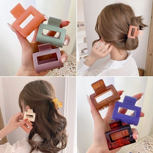 Rectangle cutout hair claws in various matte and glossy candy colors shown on hair