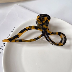 Close-up of a tortoiseshell acetate hair claw clip with a stylish hollow twisted design
