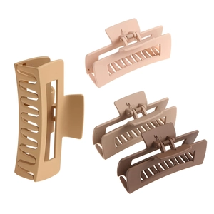 Detail showing four large matte hair claw clips in beige, light brown, and dark brown shades