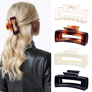 Detail of four large rectangular claw clips in clear, tortoiseshell, cream and black colors