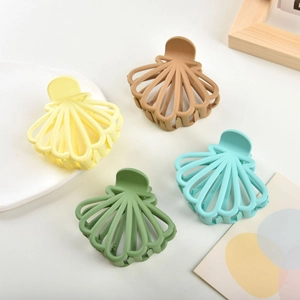 Detail view of shell-shaped matte hair claws in four elegant Morandi colors