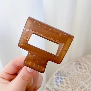 Detail view of a French vintage rectangle hair claw clip in deep amber resin finish