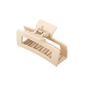 Détail d'une grande pince à cheveux rectangulaire beige mat avec ressort métallique