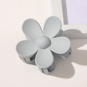 Macro detail of a matte grey-blue flower hair claw clip with a premium frosted finish
