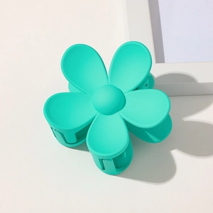 Detail of high-quality mint green matte plastic flower hair claw clip on white background
