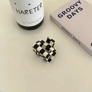 Detail view of checkerboard pattern hair claw clip with vintage acetate finish for women