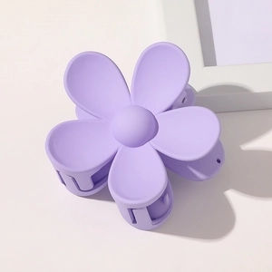 Close-up of a matte purple flower hair claw clip with a minimalist five-petal design