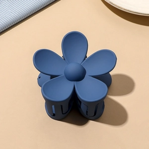 Detailed top view of matte navy blue flower hair claw clip with frosted texture