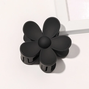 Detailed view of matte black flower hair claw clip with a five-petal floral design