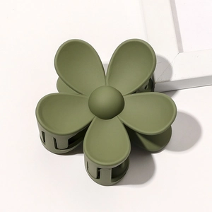Macro detail of matte green flower hair claw clip with durable multi-tooth grip design