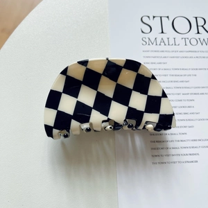 Macro shot of checkered pattern acetate hair claw clip with smooth polished finish