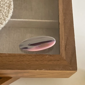 Handmade oval acetate hair claw with purple and pink marble effect in a display box