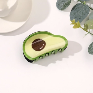 Dettaglio della creativa molletta per capelli ad avocado con finitura lucida e smiley