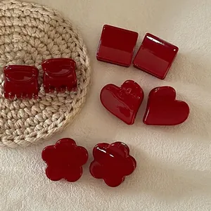 Lot de barrettes à cheveux rouge foncé avec formes carrées cœur et fleur sur tapis