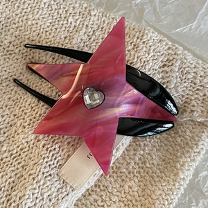 Deep pink star-shaped acetate hair claw with heart rhinestone on knit background
