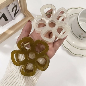 Dettaglio delle mollette per capelli a fiori in resina bianco crema e verde oliva