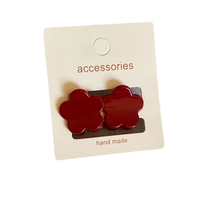 Paire de boucles d'oreilles fleurs rouge foncé avec finition brillante sur carte